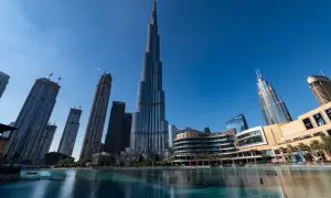 Burj Khalifa, najwyższy budynek w Dubaju, góruje nad nowoczesnym krajobrazem miasta, odbijając się w spokojnych wodach fontanny.