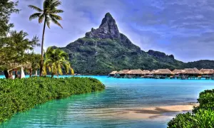 Rajskie widoki z Bora Bora: palmy, turkusowa woda i domki na wodzie. Marzenie o lotach do tego raju.