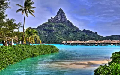 Rajskie widoki z Bora Bora: palmy, turkusowa woda i domki na wodzie. Marzenie o lotach do tego raju.