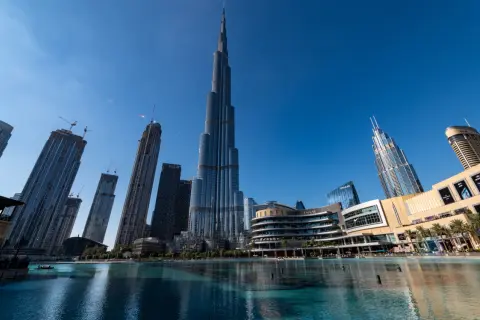 Burj Khalifa, najwyższy budynek w Dubaju, góruje nad nowoczesnym krajobrazem miasta, odbijając się w spokojnych wodach fontanny.