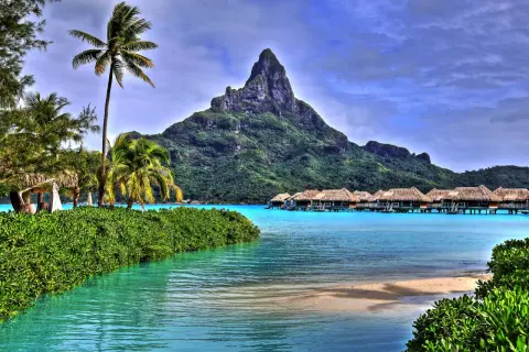 Rajskie widoki z Bora Bora: palmy, turkusowa woda i domki na wodzie. Marzenie o lotach do tego raju.