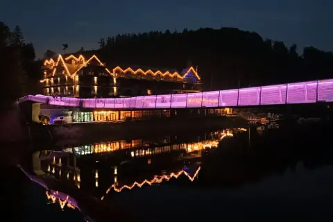 Hotel z mostem oświetlonym na fioletowo, odbijający się w wodzie. Idealne miejsce na weekendowe wypady, jedno z ciekawych miejsc do 100 km od Katowic.