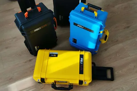Trzy walizki Peli Air: czarna, niebieska i żółta. Zastanawiasz się, czego nie można mieć w bagażu podręcznym? Te walizki są idealne na sprzęt, który musi być bezpieczny.
