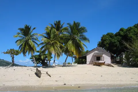 Piękna plaża z palmami, domkiem i łodzią. Zastanawiasz się, ile się leci na Madagaskar? To raj na ziemi!