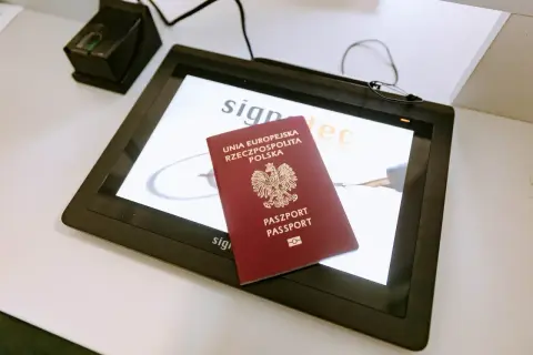 Polski paszport na ekranie z logo "signatec". Czy do Dubaju trzeba paszport? Tak, do podróży zagranicznych, w tym do Dubaju, potrzebny jest paszport.
