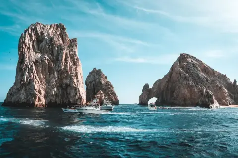 Łodzie koło skalnych formacji w Cabo San Lucas. Zastanawiasz się, ile się leci do Meksyku, by zobaczyć takie widoki?