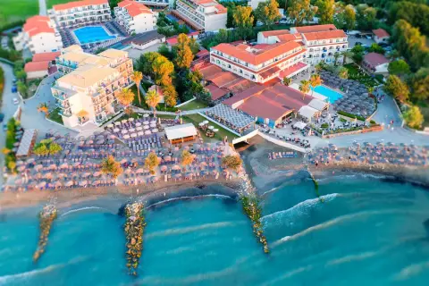 Widok z lotu ptaka na hotel z basenem i plażą pełną leżaków i parasoli. Idealne miejsce na wakacje, jak z marzeń, niczym z katalogu Itaka.