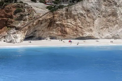 Piękna plaża Porto Katsiki z turkusową wodą i stromymi klifami. Schody prowadzą do jaskini.