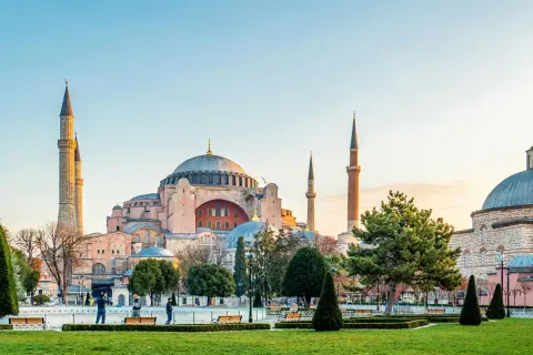 Majestatyczna Hagia Sophia w Stambule, z jej kopułą i minaretami, góruje nad zielonym parkiem.