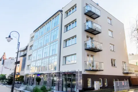 Nowoczesny hotel Lazur Świnoujście z przeszkloną fasadą i balkonami.