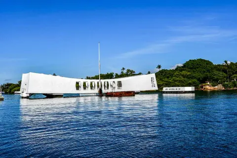Pomnik USS Arizona w Pearl Harbor, biała konstrukcja nad wodą, upamiętnia tragiczne wydarzenia.