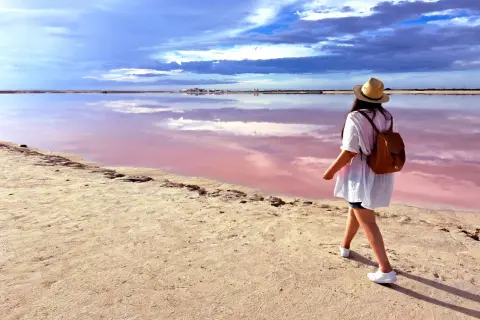 Spacerka po niezwykłym, różowym jeziorze w Alicante. Chmurki odbijają się w wodzie, tworząc magiczny krajobraz.
