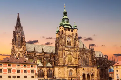 Majestatyczny zamek praski z wieżami i placem pełnym turystów. Warto kupić zamek praski bilety, by zwiedzić to miejsce.