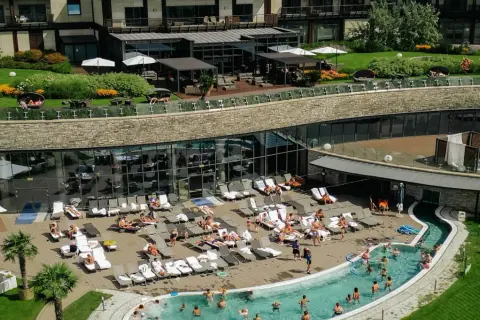 Hotel Arłamów ceny: relaks przy basenie i w spa. Widok z góry na basen, leżaki i zielony teren.