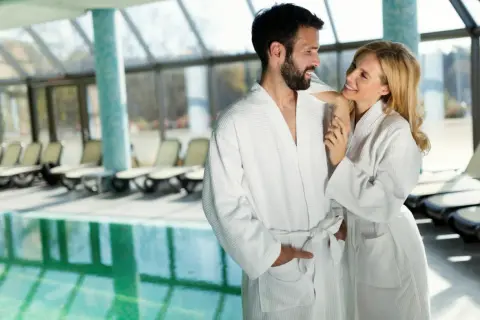 Para w szlafrokach przy basenie w spa.