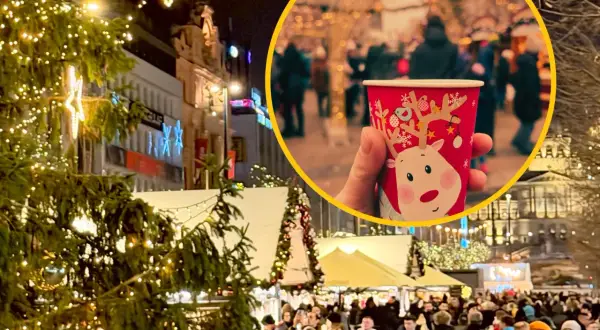 Ciepły kubek z reniferem na jarmarku bożonarodzeniowym w Pradze. Tłumy ludzi, choinki i świąteczne iluminacje tworzą magiczną atmosferę.
