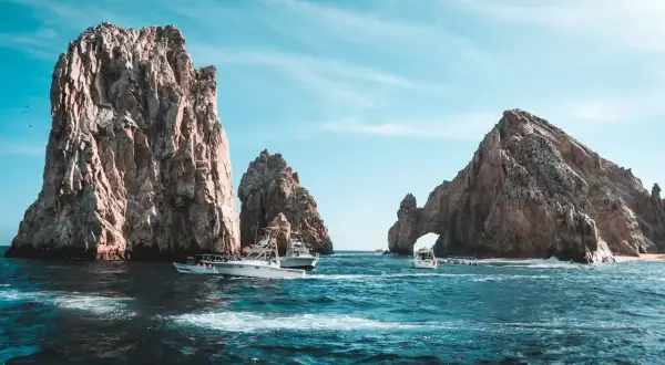 Łodzie koło skalnych formacji w Cabo San Lucas. Zastanawiasz się, ile się leci do Meksyku, by zobaczyć takie widoki?