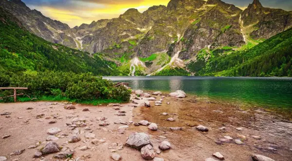 Górskie jezioro Morskie Oko, jedno z najpiękniejszych miejsc w Polsce, otoczone zielonymi zboczami i skalistymi szczytami.