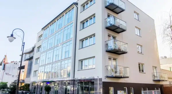 Nowoczesny hotel Lazur Świnoujście z przeszkloną fasadą i balkonami.