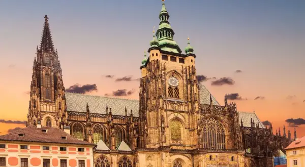 Majestatyczny zamek praski z wieżami i placem pełnym turystów. Warto kupić zamek praski bilety, by zwiedzić to miejsce.
