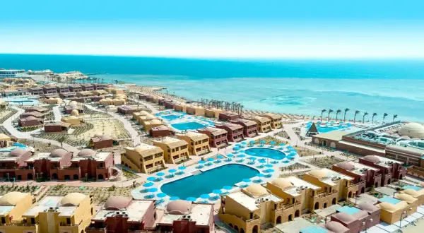 Widok z lotu ptaka na kompleks hotelowy Pickalbatros w Marsa Alam. Wiele budynków z kopułami, baseny i plaża nad Morzem Czerwonym.