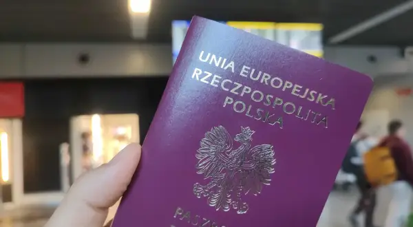 Polski paszport w dłoni, gotowy do podróży. Może to być początek drogi po wizę do Anglii.