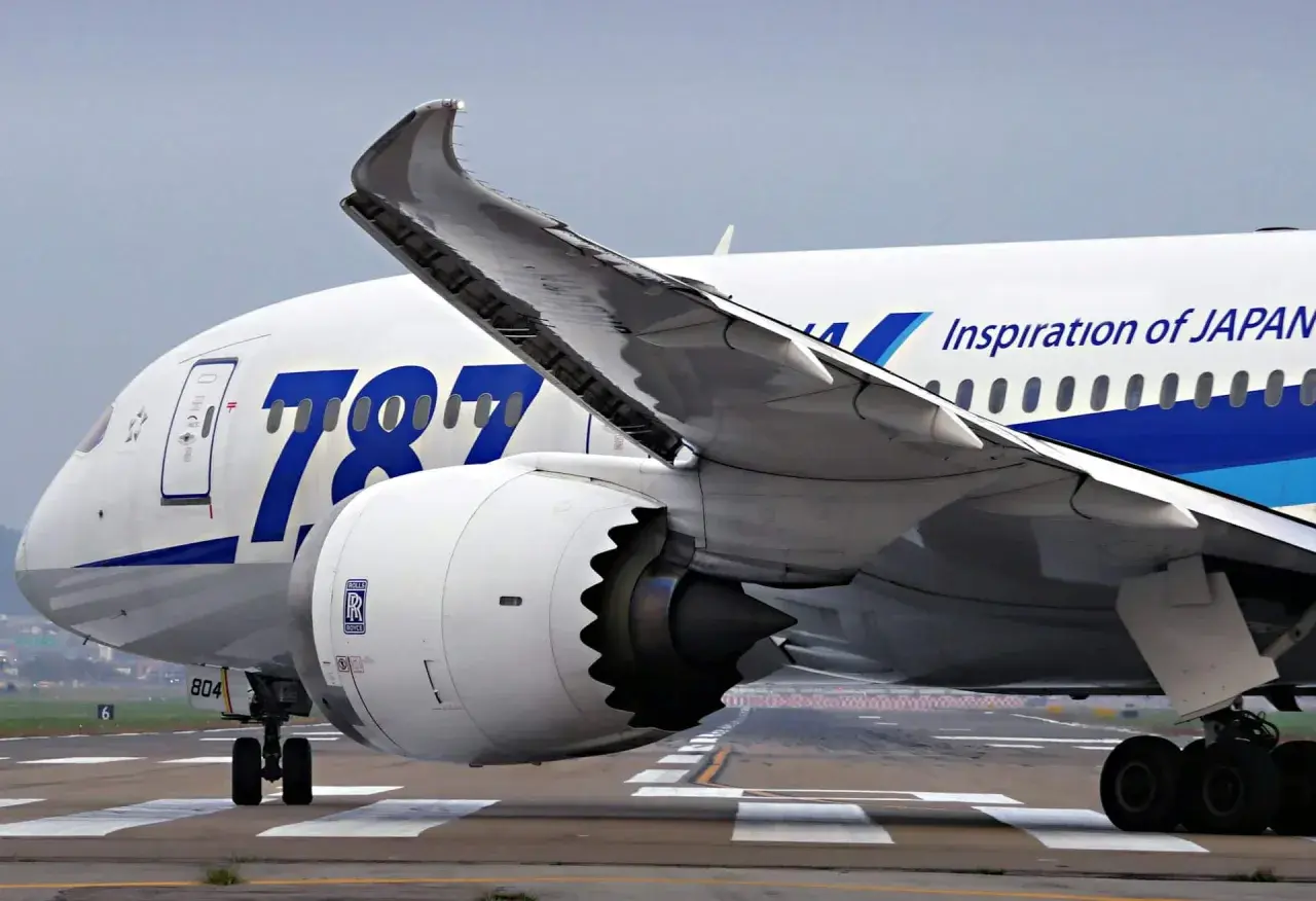 Boeing Dreamliner z napisem "Inspiration of JAPAN" na skrzydle, kołami podwozia i silnikiem Rolls-Royce.