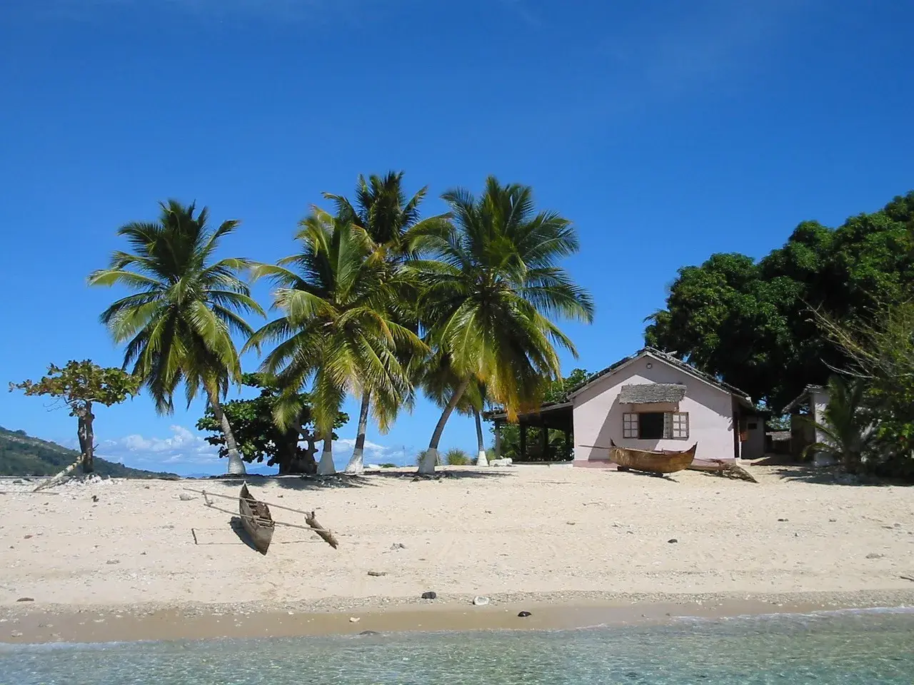 Piękna plaża z palmami, domkiem i łodzią. Zastanawiasz się, ile się leci na Madagaskar? To raj na ziemi!