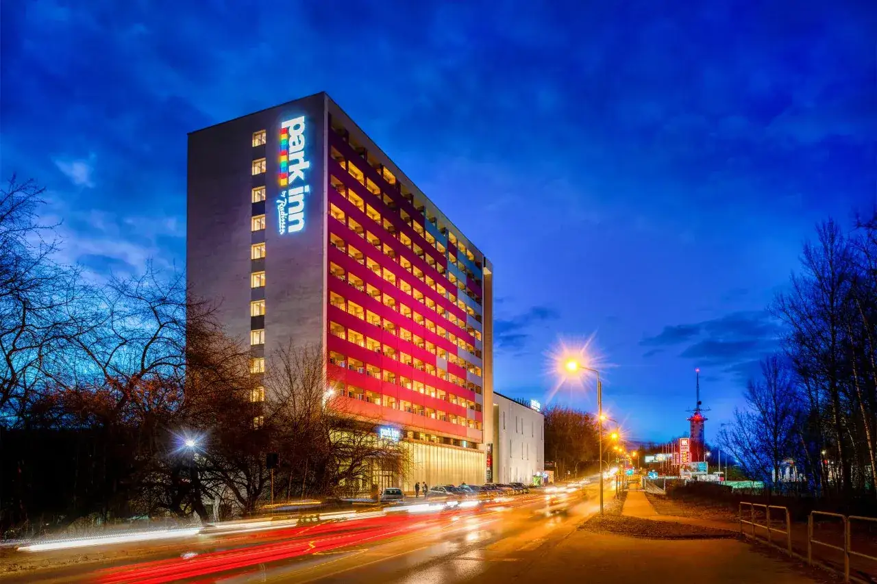Wieczorna panorama miasta z oświetlonym budynkiem Park Inn Hotel Katowice.