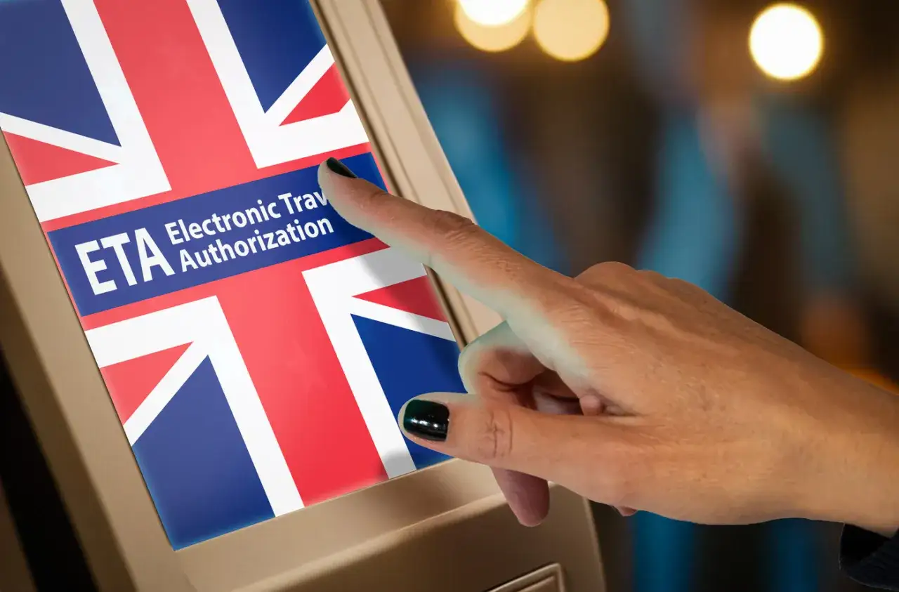 Palec dotyka ekranu z flagą Wielkiej Brytanii i napisem ETA. Zastanawiasz się, ile kosztuje ETA do UK?