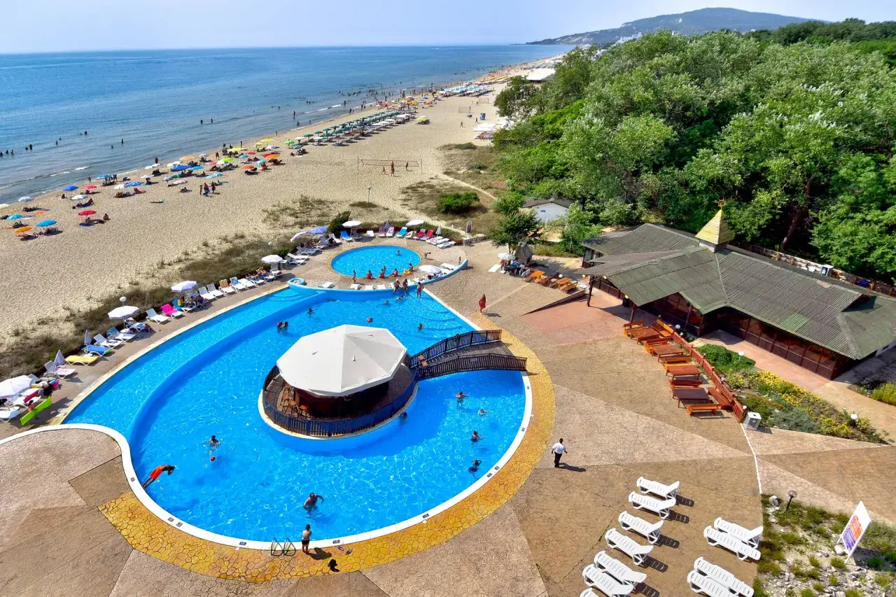 Słoneczna plaża i baseny w Albena Bułgaria. Ludzie odpoczywają na piasku i kąpią się w turkusowej wodzie.