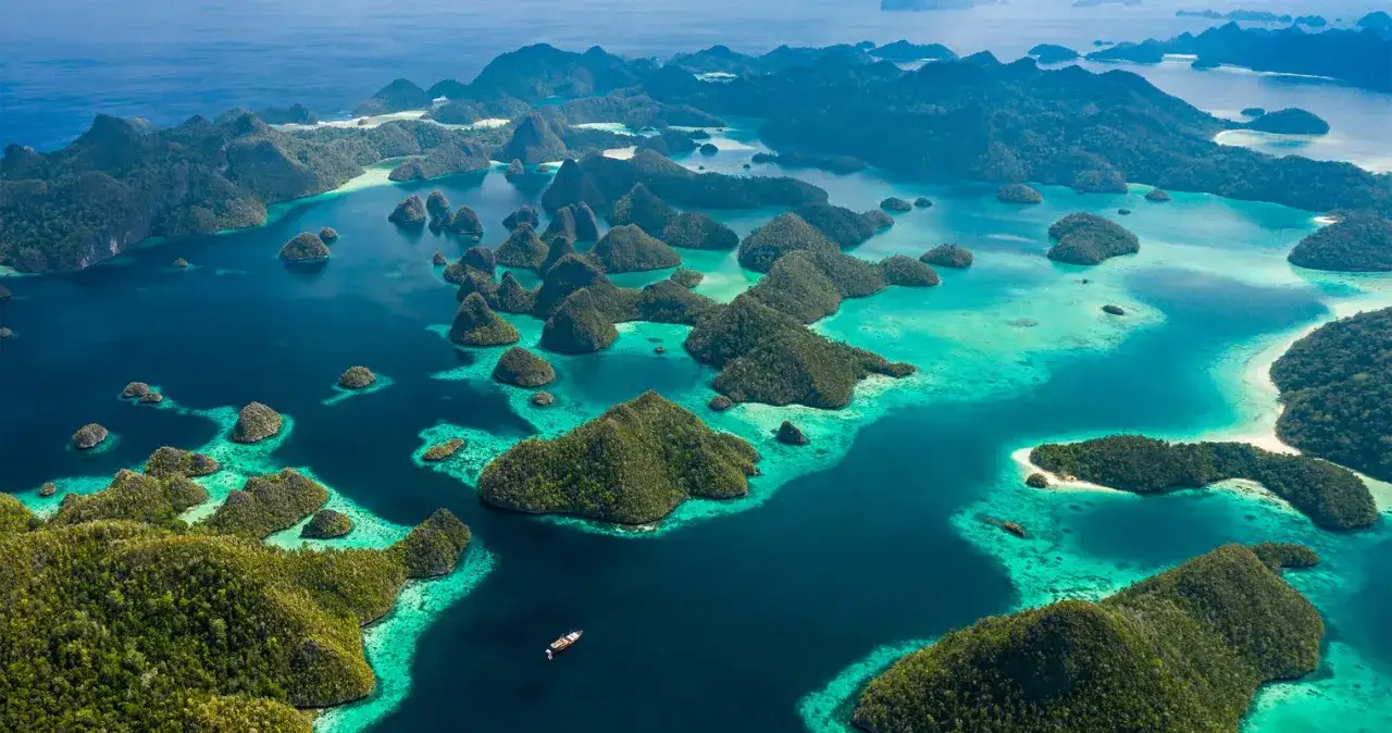 Rajskie krajobrazy Raja Ampat: bujne, zielone wyspy wyrastające z turkusowych wód.