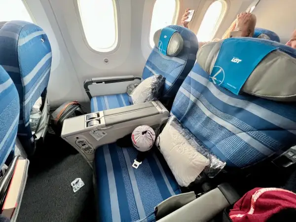 Komfortowe fotele LOT premium economy z poduszkami i kocami. Czas na relaks podczas podróży.