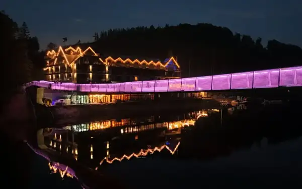 Hotel z mostem oświetlonym na fioletowo, odbijający się w wodzie. Idealne miejsce na weekendowe wypady, jedno z ciekawych miejsc do 100 km od Katowic.