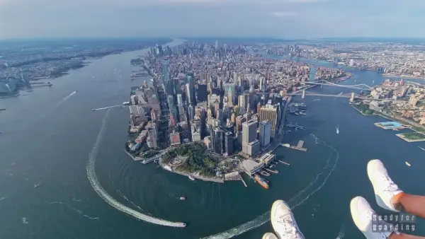 Widok z lotu ptaka na Manhattan, pełen drapaczy chmur, rzekę i mosty. Widać, w jakim stanie jest Nowy Jork – tętniący życiem, dynamiczny.