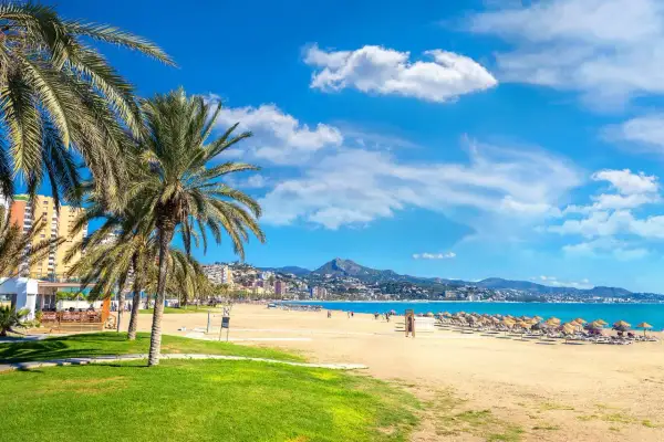 Malaga plaże: palmy, złoty piasek, turkusowe morze i góry w tle. Idealne miejsce na relaks.