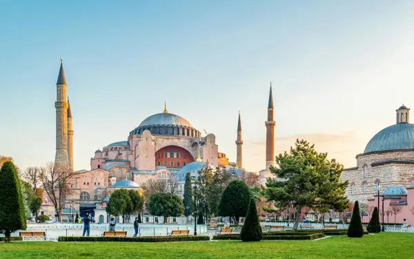 Majestatyczna Hagia Sophia w Stambule, z jej kopułą i minaretami, góruje nad zielonym parkiem.