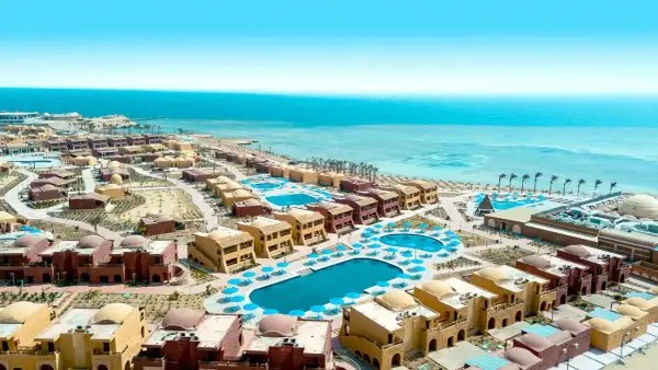 Widok z lotu ptaka na kompleks hotelowy Pickalbatros w Marsa Alam. Wiele budynków z kopułami, baseny i plaża nad Morzem Czerwonym.