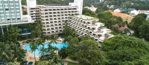 Luksusowy hotel z basenem i palmami, otoczony bujną zielenią, przypomina tropikalny raj, prawdziwe shangri la.