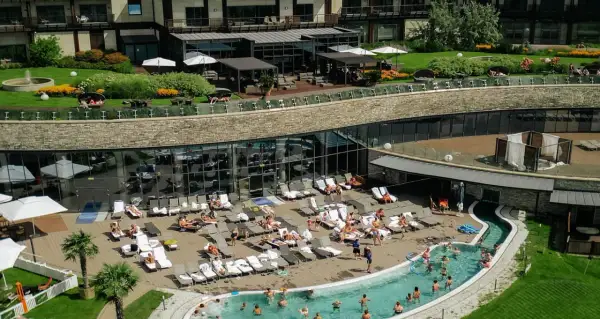 Hotel Arłamów ceny: relaks przy basenie i w spa. Widok z góry na basen, leżaki i zielony teren.