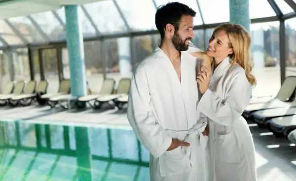 Para w szlafrokach przy basenie w spa.
